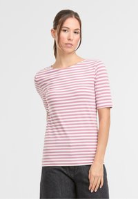Gestreiftes T-Shirt in Hellrosa und Weiß, aus weichem Stoff, runder Halsausschnitt, kurze Ärmel, taillierte Form, kombiniert mit dunklen Jeans.