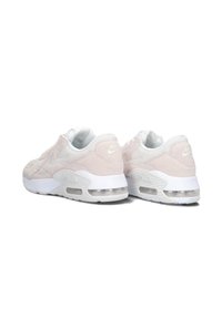 Las zapatillas Nike Air Max cuentan con un upper de ante y malla en un suave tono rosa, acentos blancos y amortiguación de aire visible en una mediasuela blanca.