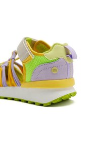 Sandale violette et jaune avec des accents en maille et une semelle en caoutchouc ; elle dispose d'une bande velcro et d'un dessus texturé pour la respirabilité. Semelle extérieure verte.
