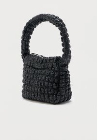 Μικρή μαύρη τσάντα με ραβδωτή, υφή και στρογγυλεμένη, μαξιλαρωτή λαβή, με φερμουάρ στο πάνω μέρος.