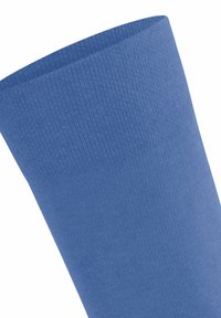 Chaussette bleue avec un motif tricoté texturé, dotée d'un bord supérieur lisse et d'une forme effilée, fabriquée à partir d'un tissu doux et extensible.
