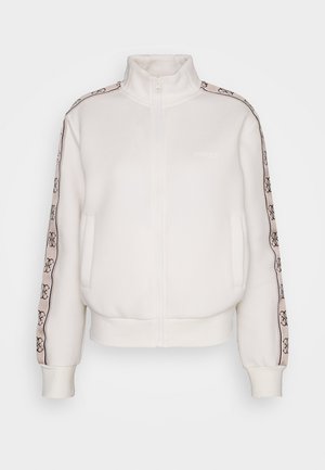 Sweat-shirt zippé blanc avec col montant, conçu dans un tissu doux. Présente un logo et une bande décorative le long des manches dans des tons contrastés.