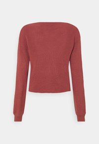 Maglione a costine cropped di colore arancio bruciato. Caratterizzato da maniche lunghe e un collo ampio, con una texture liscia e una silhouette aderente.
