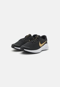 Crne sportske cipele od mrežastog materijala, s zlatnim Swoosh logotipom, bijelim srednjim dijelom i crnim gumennim potplatom s teksturiranim gripom.