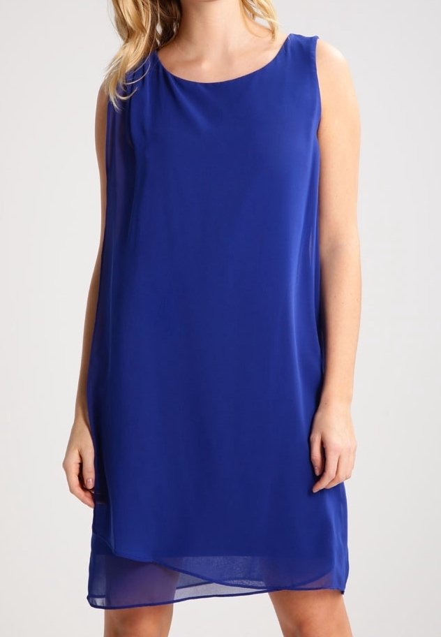 Robe bleu royal sans manches, longueur au genou, avec un ourlet en tulle superposé, portée par une personne debout sur un fond uni.