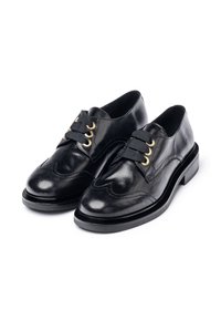 Black leather dress shoes with rounded toe, decorative stitching, two gold-tone eyelets, and black ribbon laces; thick black sole.