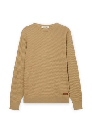 Beige langærmet sweater med tekstureret vaffelmønster, rund halsudskæring, ribkant ved ærmer og kant samt lille brun etiket nær taljen.