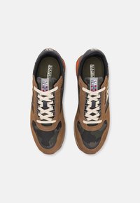 Sneaker in suede marrone e rete camouflage con lacci crema, dettagli neri e un inserto arancione sul tallone. Etichetta del logo visibile sulla linguetta.