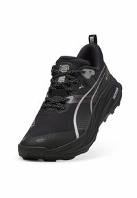 Scarpa da corsa nera con tomaia in mesh testurizzato, dettagli riflettenti, collo imbottito e lacci a contrasto neri e bianchi con motivo a fantasia.