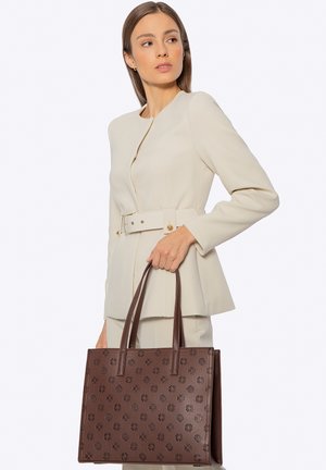 Bruine leren totebag met geperst bloempatroon, rechthoekige vorm en dubbele handvatten; gecombineerd met een crème getailleerde blazer.