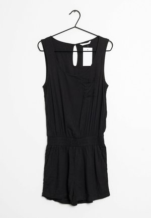 Zwarte mouwloze romper met elastische taille en klein borstzakje, hangend aan een zwarte hanger tegen een witte achtergrond.