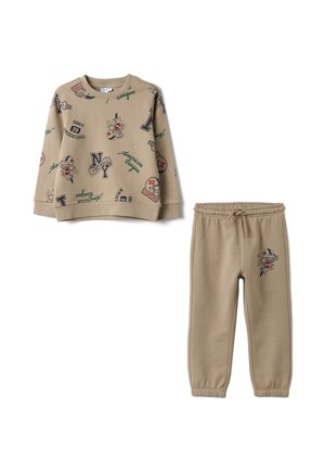 Ensemble beige pour enfants comprenant un sweat-shirt et un pantalon avec des imprimés sur le thème du football américain, incluant casques, lettres et joueurs dessinés.