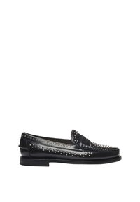 Mocassins en cuir noir avec des clous en métal le long du bord supérieur et de l'orteil. Présentent une texture lisse, un talon bas et une forme arrondie.