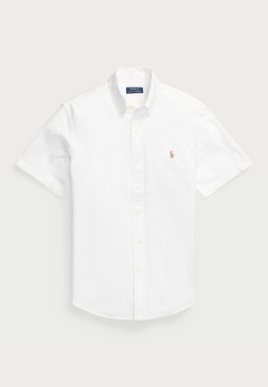 Camisa branca de mangas curtas e botão, feita de algodão, com colarinho pontudo e um pequeno logótipo bordado no lado esquerdo do peito.