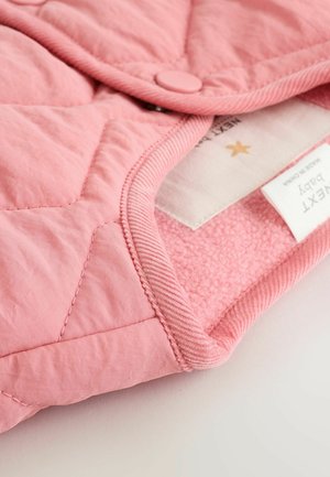 Quilted baby jacket in soft pink fabric, featuring a smooth exterior, plush lining, rounded collar, and snap closure. Label visible inside.