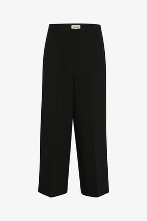 Musta laiade sääreosadega püksid, millel on elastne vöökoht ning väike "soaked" silt vöö siseküljel keskel.