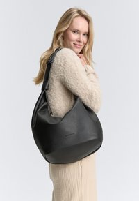Borsa hobo in pelle nera con texture a granuli e tracolla regolabile. Forma curva con apertura ampia, visibilità minima del marchio.
