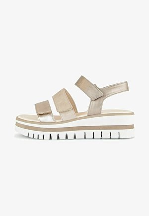 Metallic beige sandal with three straps, foam footbed, and a chunky white sole with grooves. Adjustable back strap for secure fit.