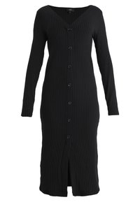 Knappad svart ribbad klänning med långa ärmar, V-ringning och en slits i fållen. Tillverkad av strukturerad tyg med en figurnära silhuett.