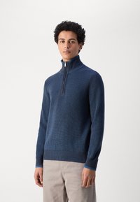 Navyblauer Strickpullover mit hohem Kragen und Viertelreißverschluss auf der Vorderseite. Eigenschaften sind eine gerippte Textur und kontrastierende blaue Akzente an den Bündchen.
