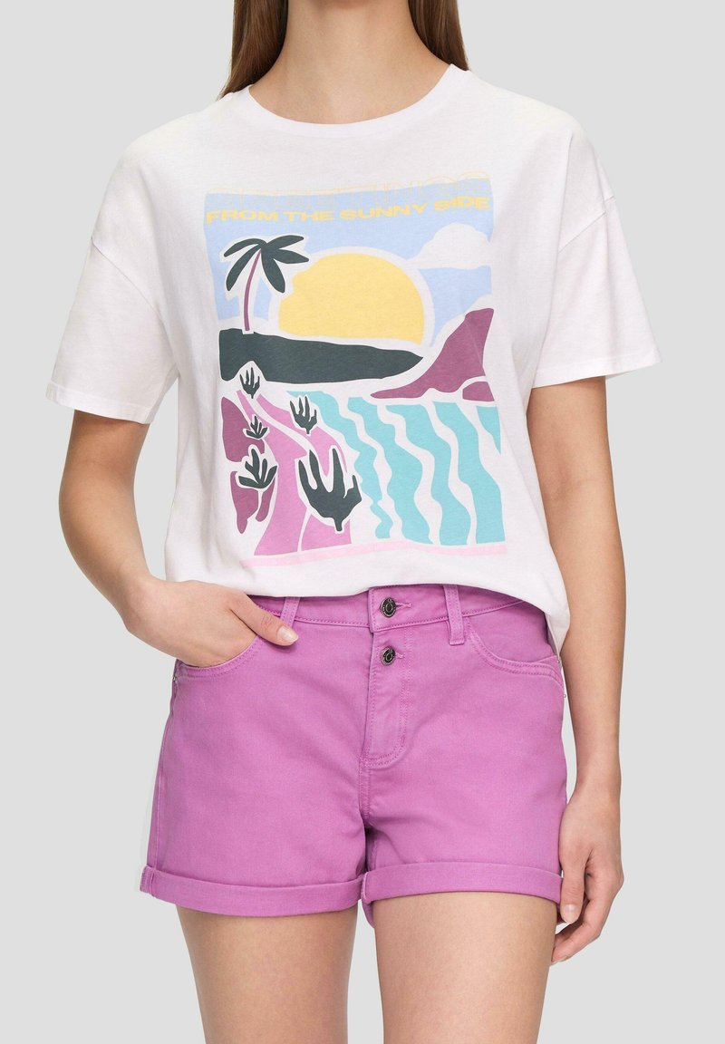 T-shirt blanche avec un graphique coloré représentant un soleil, des palmiers et des vagues. Associé à un short en denim rose, avec des ourlets roulés et deux boutons.