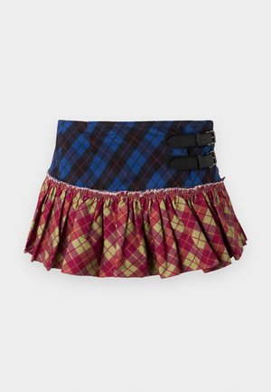 Una falda plisada con una parte superior de cuadros azules y negros, que presenta dos hebillas negras y un dobladillo rizado con un patrón de diamantes en rojo, verde y amarillo.