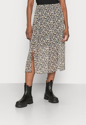Blomster midi nederdel med sideslids, båret med sorte chunky ankelstøvler og sort top, synlig fra taljen og ned.