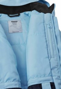 Light blue padded children's jacket interior with black lining, brand label, and a small zipper pocket on the right side.