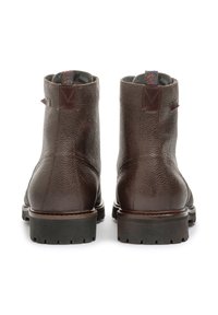 Botas de cuero marrón hasta el tobillo con acabado texturizado, punta redonda y suela negra resistente. Cuenta con una pestaña en contraste en el talón y forro con estampado.