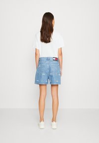 Ljust blå denimshorts med avslappnad passform, två bakfickor och broderade detaljer. Kombineras med en enkel vit t-shirt.