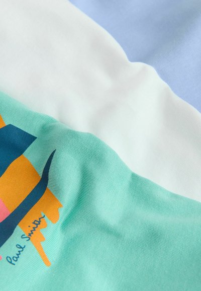 T-shirt en coton avec sections vert menthe, bleu clair et blanc ; présente un design graphique coloré et le texte "Paul Smith." Texture douce.