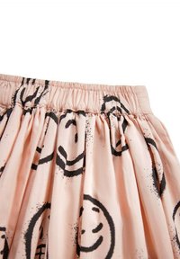 Vaaleanpunainen hame, jossa on musta hymyilevä kasvokuva, gathers-vyötärö ja pehmeä, kevyt kangas. Sisältää joustavan vyötärön ja flowing siluettia.