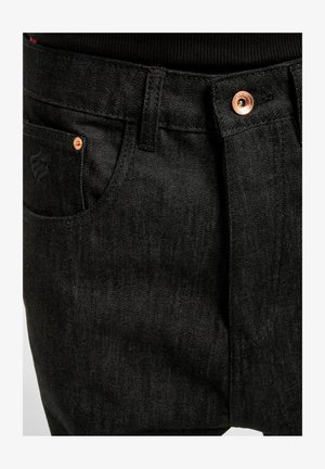 Sorte denimbukser med lige snit. Har kobberhardware, markeret syning og en sidelomme. Glat tekstur.