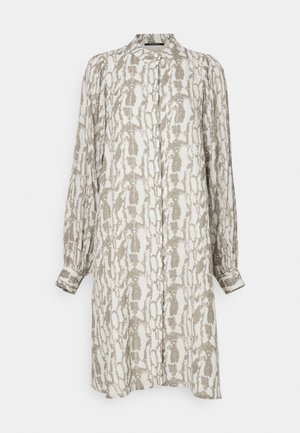 Dlhé šaty s golierom v svetlom béžovom odtieni s abstraktným vzorom v sivej farbe. Majú dlhé rukávy s gombíkovými manžetami a rovný strih.