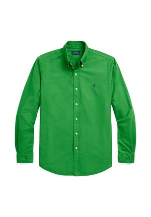 Chemise verte à manches longues avec boutons et col, avec un petit logo brodé sur la poitrine gauche, posée à plat sur fond blanc.