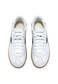 Witte sneakers van leer en suede, met groene accenten, ronde neus, vetersluiting en rubberen zolen.