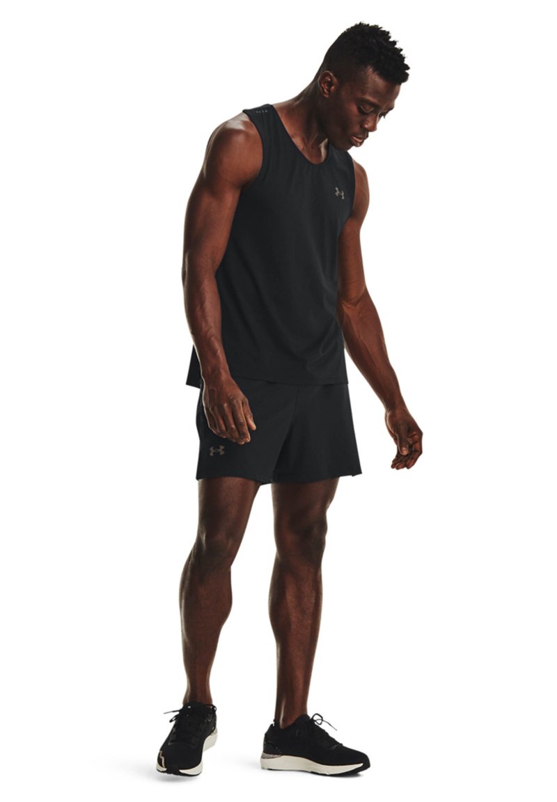 Camiseta atlética negra sin mangas y pantalones cortos, hechos de una tela ligera. Presenta el logo de Under Armour en gris oscuro. Se lleva con zapatillas negras.