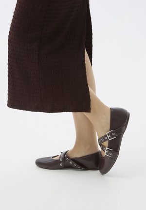 Burgunderfarbene Ballerinas mit Aussparungen und metallischen Akzenten, ausgestattet mit einer glatten Oberfläche und einem runden Zehenbereich.