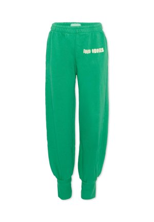 Pantalon de jogging en polaire verte avec taille et poignets élastiques, arborant un logo texte blanc sur la cuisse supérieure.