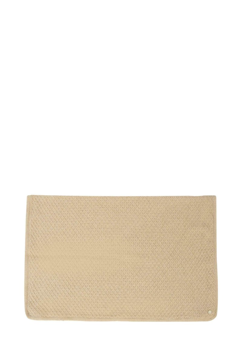 Beżowy prostokątny dywanik o fakturowanej powierzchni, z wzorem w diamenty, wykończony gładką krawędzią oraz małym okrągłym akcentem.