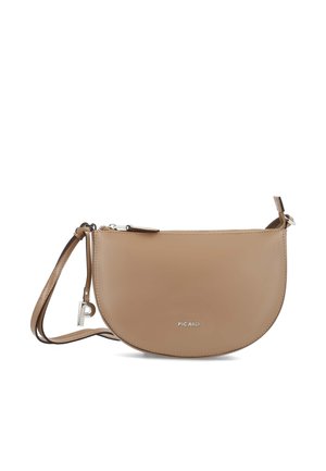 Smooth tan leather half-moon crossbody bag with zipper closure, adjustable strap, silver logo, and small silver charm on strap loop.