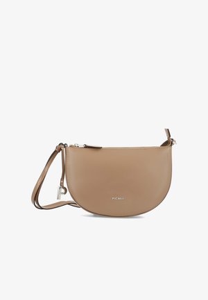 Smooth tan leather half-moon crossbody bag with zipper closure, adjustable strap, silver logo, and small silver charm on strap loop.