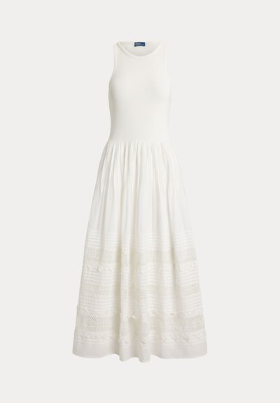 Sleeveless white dress with fitted bodice and full skirt featuring horizontal lace and embroidered patterns near the hem.