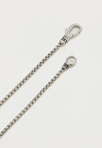 Chaîne en métal argenté avec une surface texturée, présentant deux fermoirs : un en forme de homard et un autre en boucle ronde, tous deux élégants et polis.