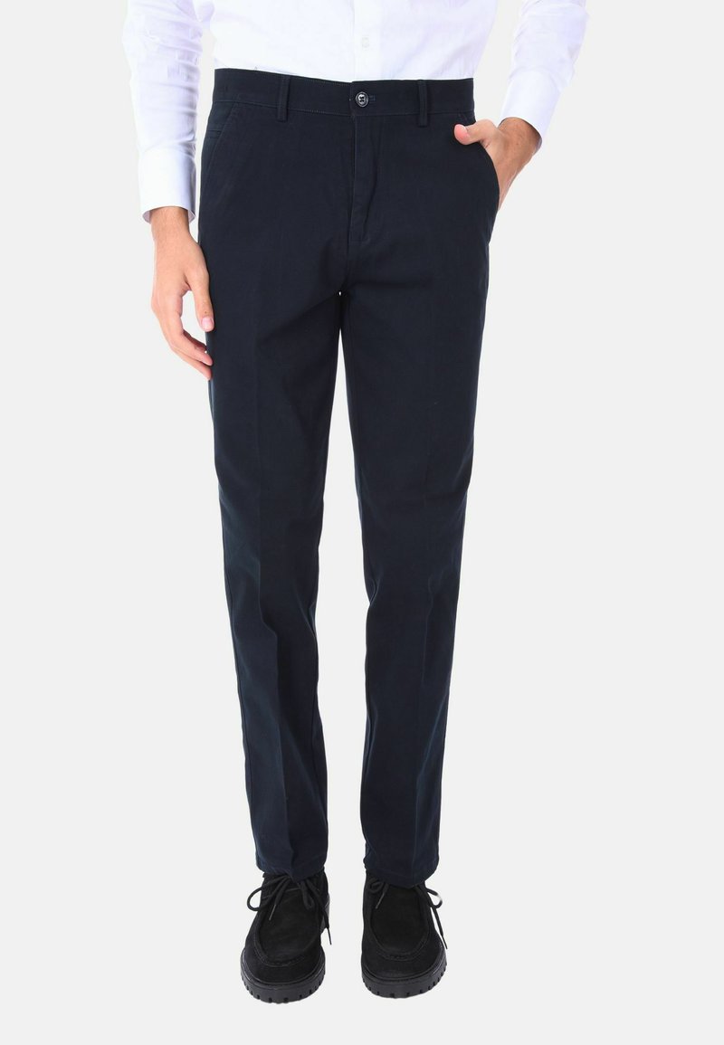 Chinos blu navy realizzati in cotone, con una vestibilità dritta, tasche anteriori e una chiusura con bottone standard. Abbinati a scarpe nere.
