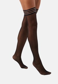 Sorte thigh-high strømper laget av gjennomsiktig materiale, med tre horisontale striper på den øvre kanten. Jevn tekstur, minimalistisk design.