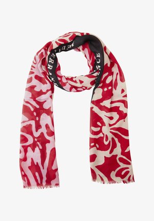 Czerwono-biały szal o abstrakcyjnym wzorze z czarną obwódką i białym napisem, lekka tkanina, postrzępione brzegi.