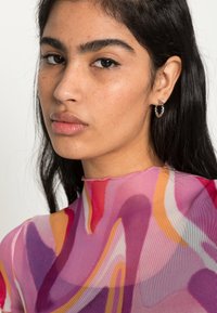 Top transparente de múltiplas cores com padrões em espiral em rosa, roxo e laranja; textura suave com decote alto e acabamento áspero.