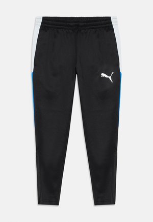 Pantalons de sport noirs avec des panneaux latéraux blancs et bleus, taille élastique, poches zippées et logo Puma blanc sur la cuisse droite.