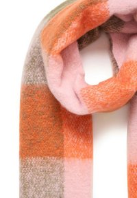 Blød strikket tørklæde med brede vandrette striber i orange, pink og beige nuancer, løst svunget med en hvid baggrund.